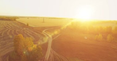 UHD 4K hava görüntüsü. Sarı kırsal alan ve toprak yol üzerinde orta-uçuş