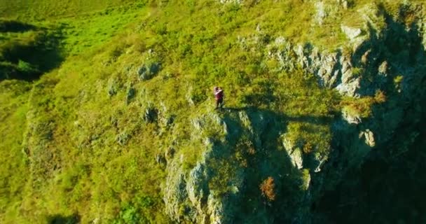 Orbital radiella flygning runt unga vandring man står på toppen av klippan. Tittar bort. — Stockvideo