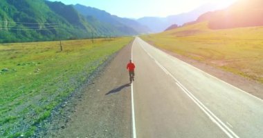 Mükemmel asfalt yol, sportif adamın arkasında alçak irtifa uçuş