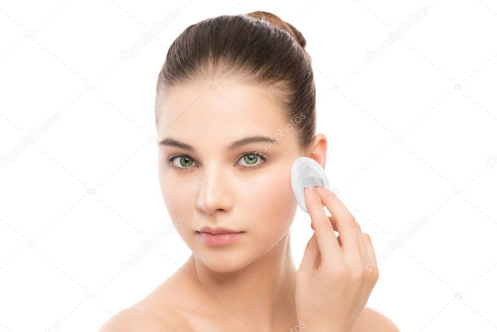 Young woman cares for face skin. Cleaning perfect fresh skin using cotton pad. Isolated.
