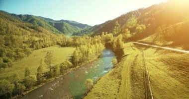 Taze dağ nehir ve güneşli yaz sabahı, çayır üzerinde havada uçuş. Kırsal toprak yol aşağıdaki.