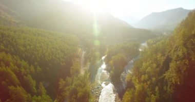 Güneşli yaz sabahında taze dağ nehri ve çayır üzerinde uçuşun ortasında. Aşağıdaki kırsal toprak yol.