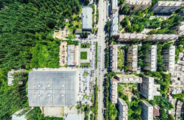Kesişen yollar, evler, binalar, parklar ve otoparklar olan havacılık şehri manzarası. Güneşli yaz panoramik resmi