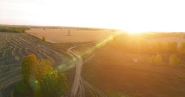 UHD 4K hava görüntüsü. Sarı kırsal alan ve toprak yol üzerinde orta-uçuş
