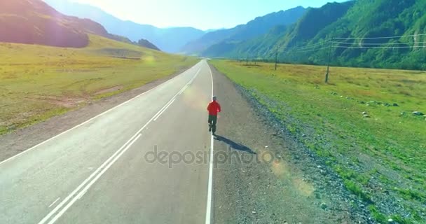 完璧なアスファルトの道路でスポーティな男の背後にある低空飛行 — ストック動画