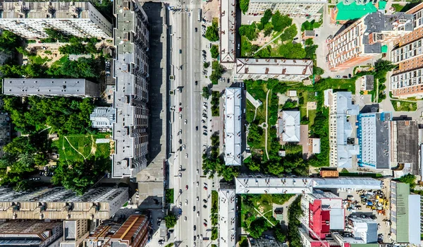 Aerial city view with crossroads and roads, houses, buildings, parks and parking lots. Sunny summer panoramic image — Stock Photo, Image