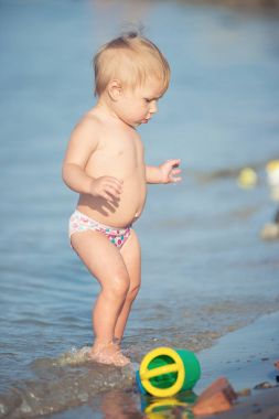 Şirin Bebek kumlu plajı ve deniz suyu oynarken.