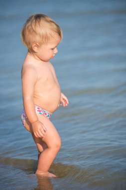 Şirin Bebek kumlu plajı ve deniz suyu oynarken.