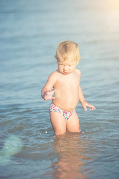 Carino bambino che gioca sulla spiaggia di sabbia e in acqua di mare . — Foto Stock