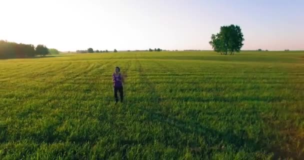 Vol de drone à basse altitude devant une femme sportive sur une route asphaltée parfaite — Video