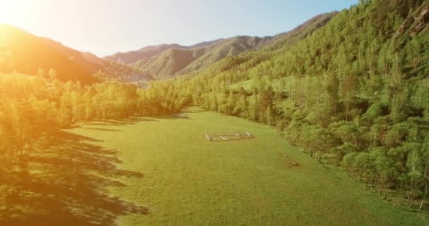 UHD 4K vista aérea. Vuelo bajo sobre el río fresco y frío de la montaña, prado y carretera en la soleada mañana de verano . — Vídeos de Stock