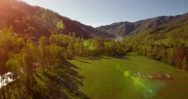 Güneşli yaz sabahında taze dağ nehri ve çayır üzerinde uçuşun ortasında. Aşağıdaki kırsal toprak yol.