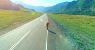 Mükemmel asfalt yol, sportif adamın arkasında alçak irtifa uçuş