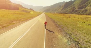 Mükemmel asfalt yol, sportif adamın arkasında alçak irtifa uçuş