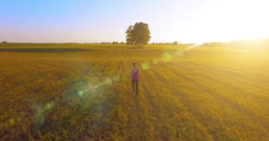 UHD 4k havadan görünümü. Alçak irtifa uçuş kırsal alan, sportif kadının önünde