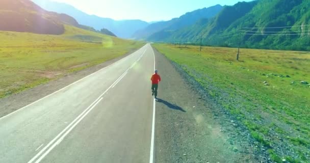 Полет на малой высоте позади спортсмена на идеальной асфальтовой дороге — стоковое видео