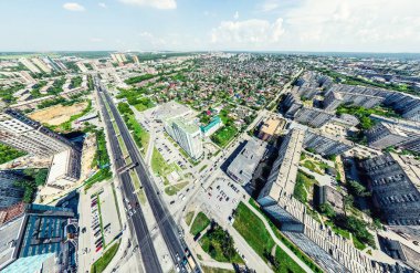 Kesişen yollar, evler, binalar, parklar ve otoparklar olan havacılık şehri manzarası. Güneşli yaz panoramik resmi