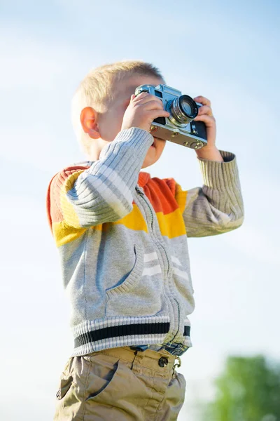 Little boy with an old camera shooting outdoor. — Stock Photo, Image