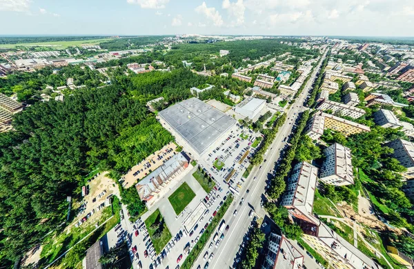 Vista aérea de la ciudad con encrucijadas y caminos, casas, edificios, parques y estacionamientos. Imagen panorámica soleada de verano — Foto de Stock