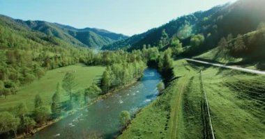 Taze dağ nehir ve güneşli yaz sabahı, çayır üzerinde havada uçuş. Kırsal toprak yol aşağıdaki.