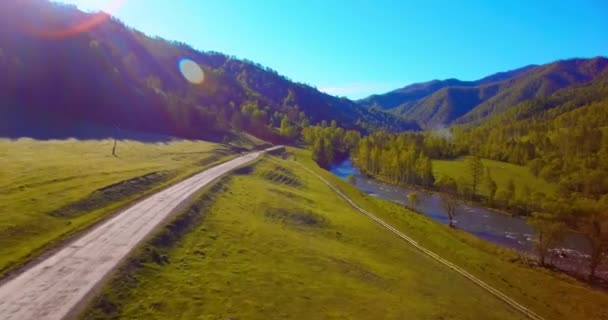 夏日阳光明媚的早晨,空中飞越新鲜的山河和草地.下面的乡村土路. — 图库视频影像
