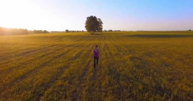 UHD 4k havadan görünümü. Alçak irtifa uçuş kırsal alan, sportif kadının önünde