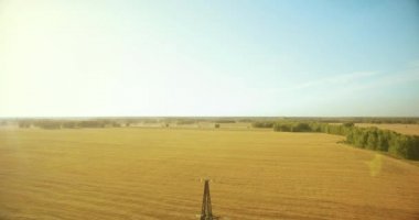 Yüksek voltajlı elektrik kulesi ve yeşil ve sarı alandaki elektrik hatları yakınında dikey hareket.