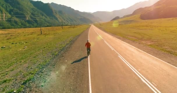 Volo a bassa quota dietro di uomo sportivo su strada asfaltata perfetta — Video Stock