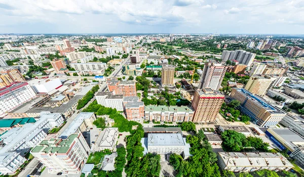 Vista aérea de la ciudad con encrucijadas y caminos, casas, edificios, parques y estacionamientos. Imagen panorámica soleada de verano —  Fotos de Stock