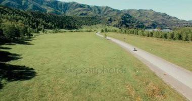 Uçuş otomobil tepeler ve çayır de dolambaçlı bir yol. Kırsal otoyol aşağı.