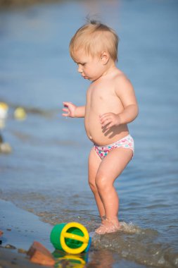 Şirin Bebek kumlu plajı ve deniz suyu oynarken.