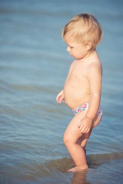 Şirin Bebek kumlu plajı ve deniz suyu oynarken.