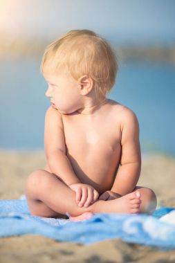 Şirin Bebek denize yakın kum plajındaki oyuncaklar ile oynama.