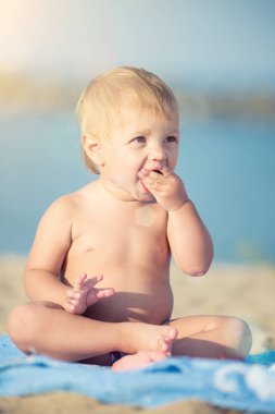 Şirin Bebek denize yakın kum plajındaki oyuncaklar ile oynama.
