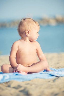 Şirin Bebek denize yakın kum plajındaki oyuncaklar ile oynama.