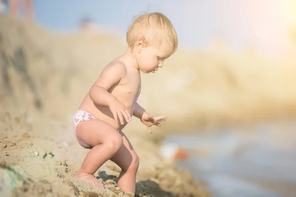 Carino bambino che gioca con i giocattoli sulla spiaggia di sabbia vicino al mare . — Foto Stock