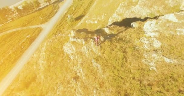 崖の上に立っている若者ハイキングの周りの放射状軌道。距離に見える. — ストック動画
