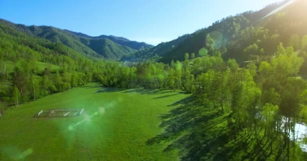 UHD 4K vista aérea. Vuelo bajo sobre el río fresco y frío de la montaña, prado y carretera en la soleada mañana de verano . — Vídeos de Stock