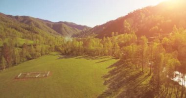 Güneşli yaz sabahında taze dağ nehri ve çayır üzerinde uçuşun ortasında. Aşağıdaki kırsal toprak yol.