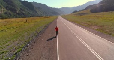 Mükemmel asfalt yol, sportif adamın arkasında alçak irtifa uçuş