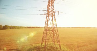 Yüksek voltajlı elektrik kulesi ve yeşil ve sarı alandaki elektrik hatları yakınında dikey hareket.