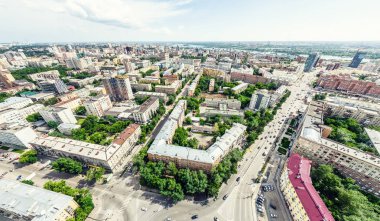 Kesişen yollar, evler, binalar, parklar ve otoparklar olan havacılık şehri manzarası. Güneşli yaz panoramik resmi