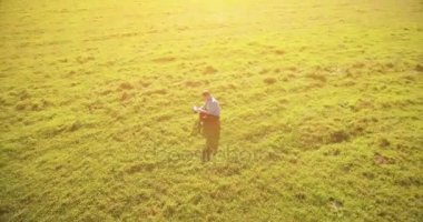 UHD 4k havadan görünümü. Defter pad ile yeşil çim sahasında oturan işadamı üzerinde düşük yörünge uçuş