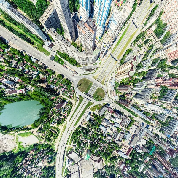 Aerial city view with crossroads and roads, houses, buildings, parks and parking lots. Sunny summer panoramic image — Stock Photo, Image