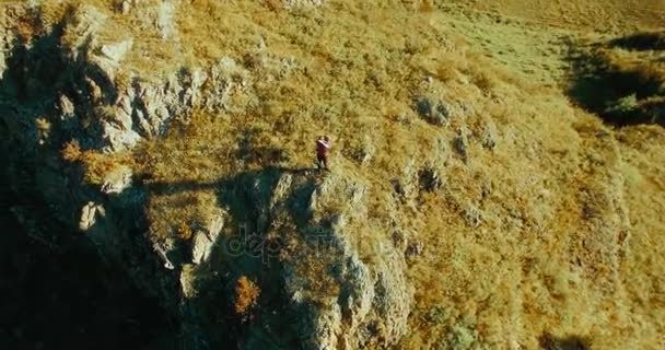 Vol radial orbital autour d'un jeune randonneur debout au sommet de la falaise. Regarde ailleurs . — Video