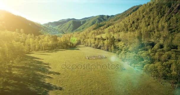 UHD 4K vista aérea. Vuelo bajo sobre el río fresco y frío de la montaña, prado y carretera en la soleada mañana de verano . — Vídeo de stock