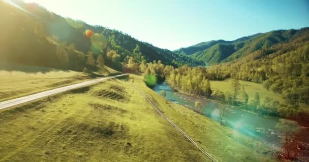 UHD 4k luchtfoto. Lage vlucht over verse koude berg rivier, weide en weg bij zonnige Zomerochtend. — Stockvideo