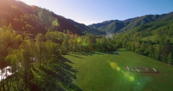 Mid air flygning över färska berg flod och äng på solig sommarmorgon. Landsbygdsvägen nedanför. — Stockvideo