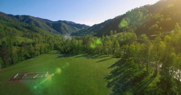 Midden in de lucht vlucht over verse bergrivier en weide op zonnige zomerochtend. Landelijke onverharde weg onder. — Stockvideo