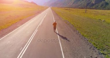 Mükemmel asfalt yolda sporcunun önünde alçak irtifa uçuşu.